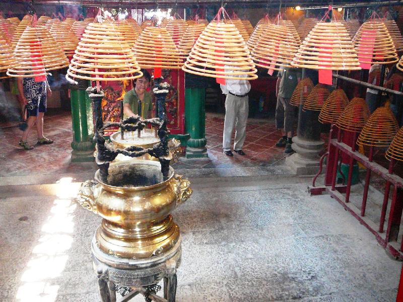 Devotees burn sacrifice money and huge bell-shaped coils of incense that hang from the temple