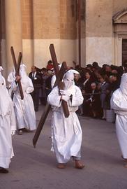 Hooded repenters pull or carry crosses.